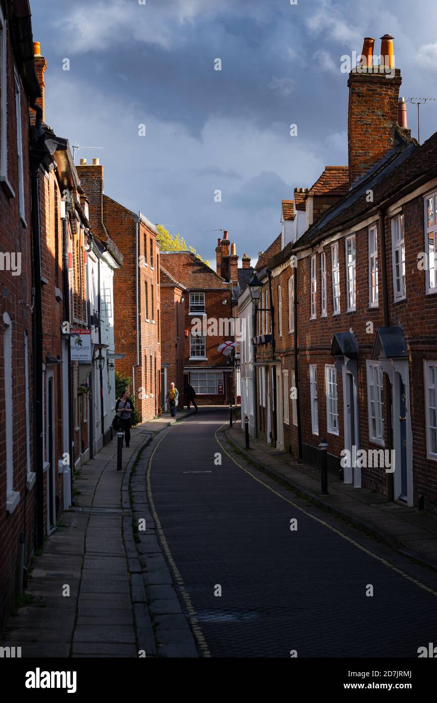 A flag of St George (the English national flag) is visible at the end of Canon Street in Winchester, Hampshire, England. Stock Photo