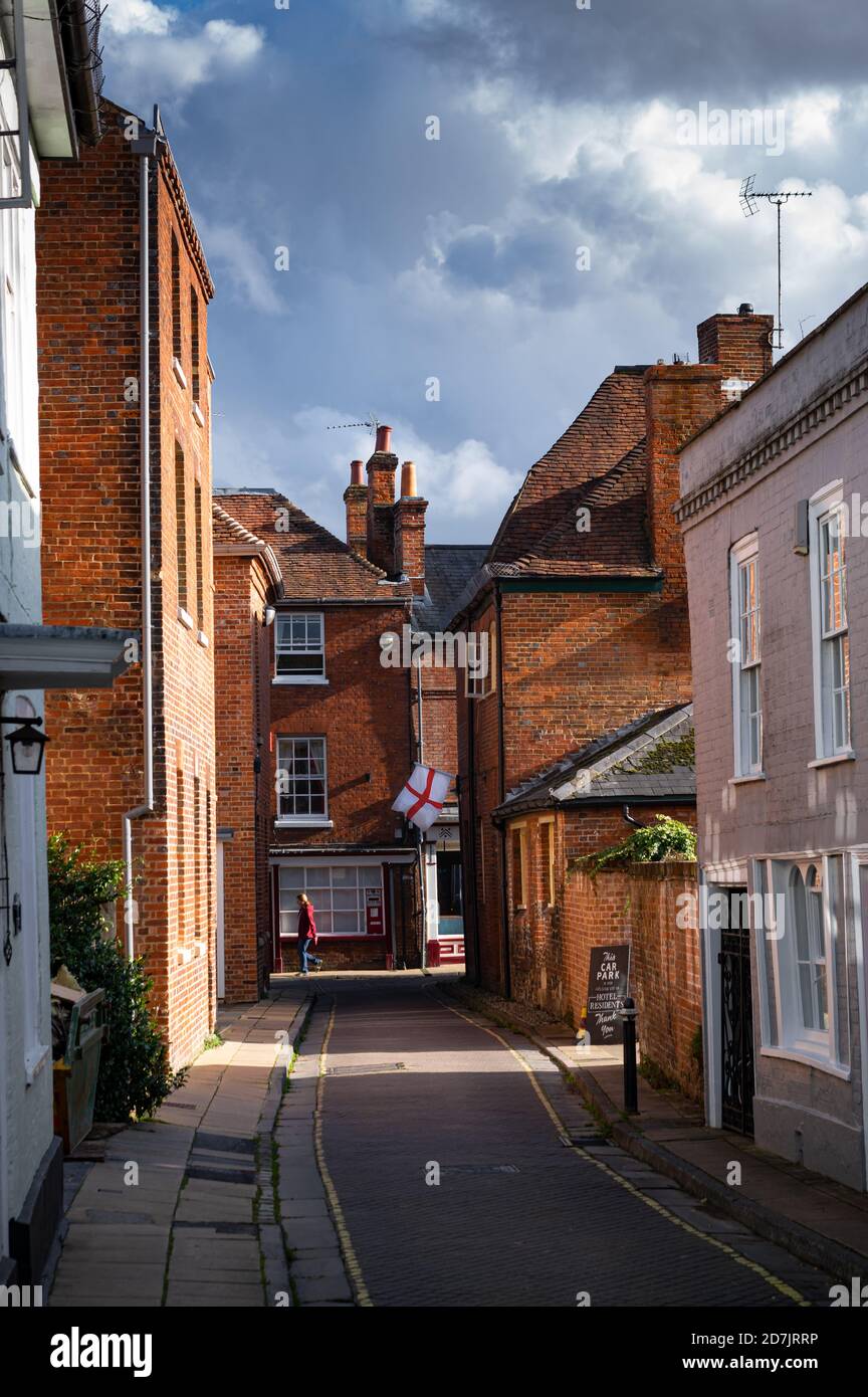 A flag of St George (the English national flag) is visible at the end of Canon Street in Winchester, Hampshire, England. Stock Photo