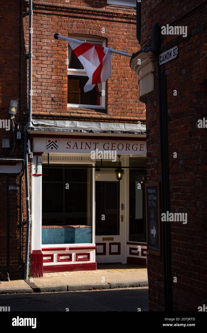 A flag of St George (the English national flag) is visible opposite the St George Tea Rooms at the end of Canon Street in Winchester, Hampshire, Engla Stock Photo