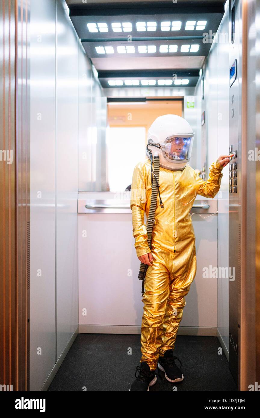 Boy wearing space suit pressing buttons in open elevator Stock Photo