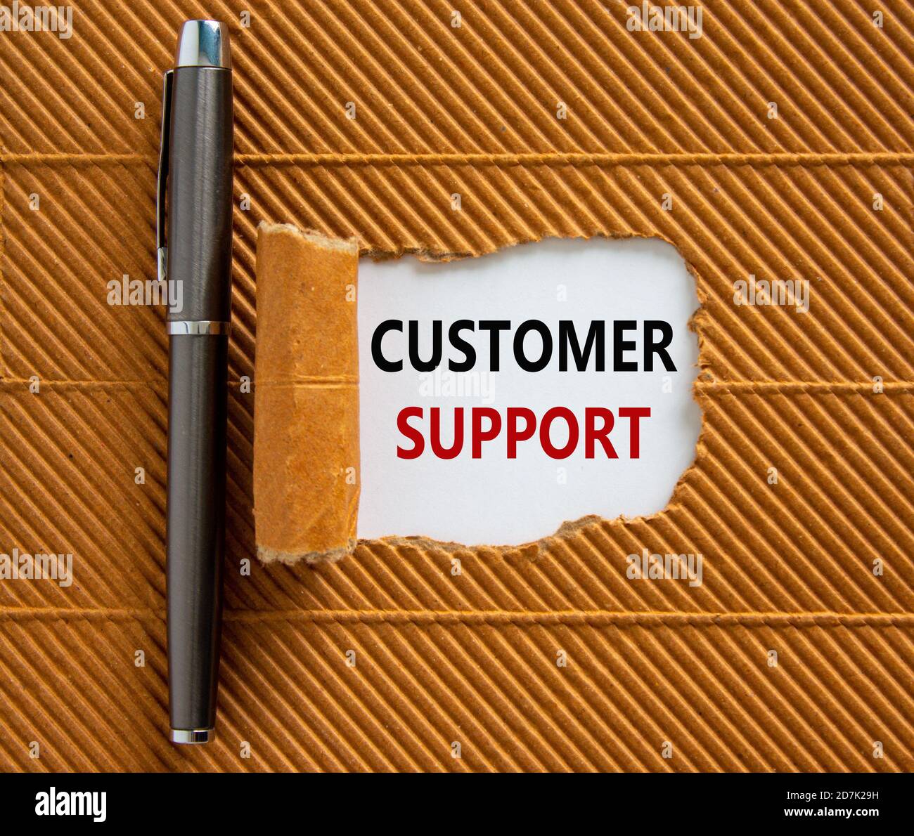 The text 'customer support' appearing behind torn brown paper ...