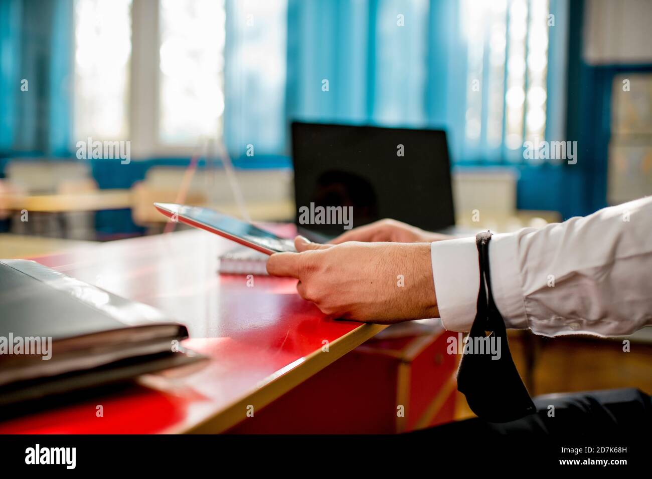 Professor in classroom using laptop and digital tablet Stock Photo