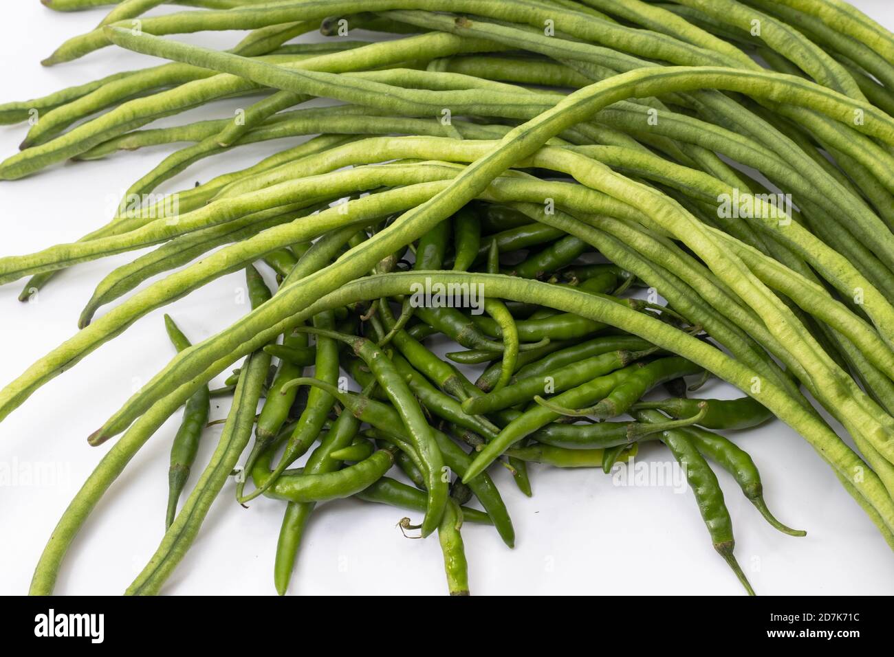 Long cowpea with chili peppers on white background Stock Photo - Alamy