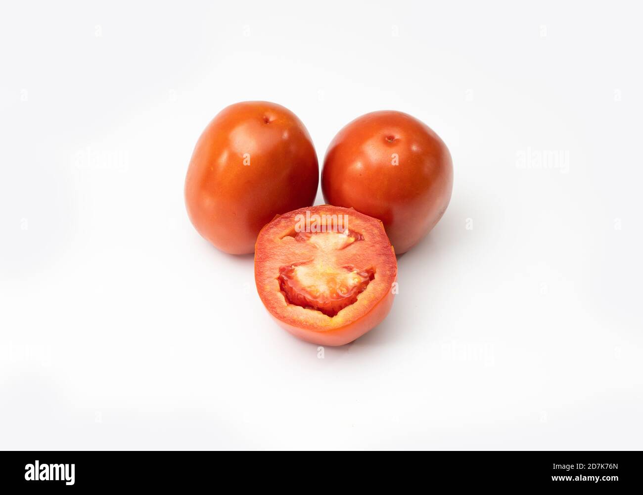 One sliced and two full tomato onwhite background Stock Photo