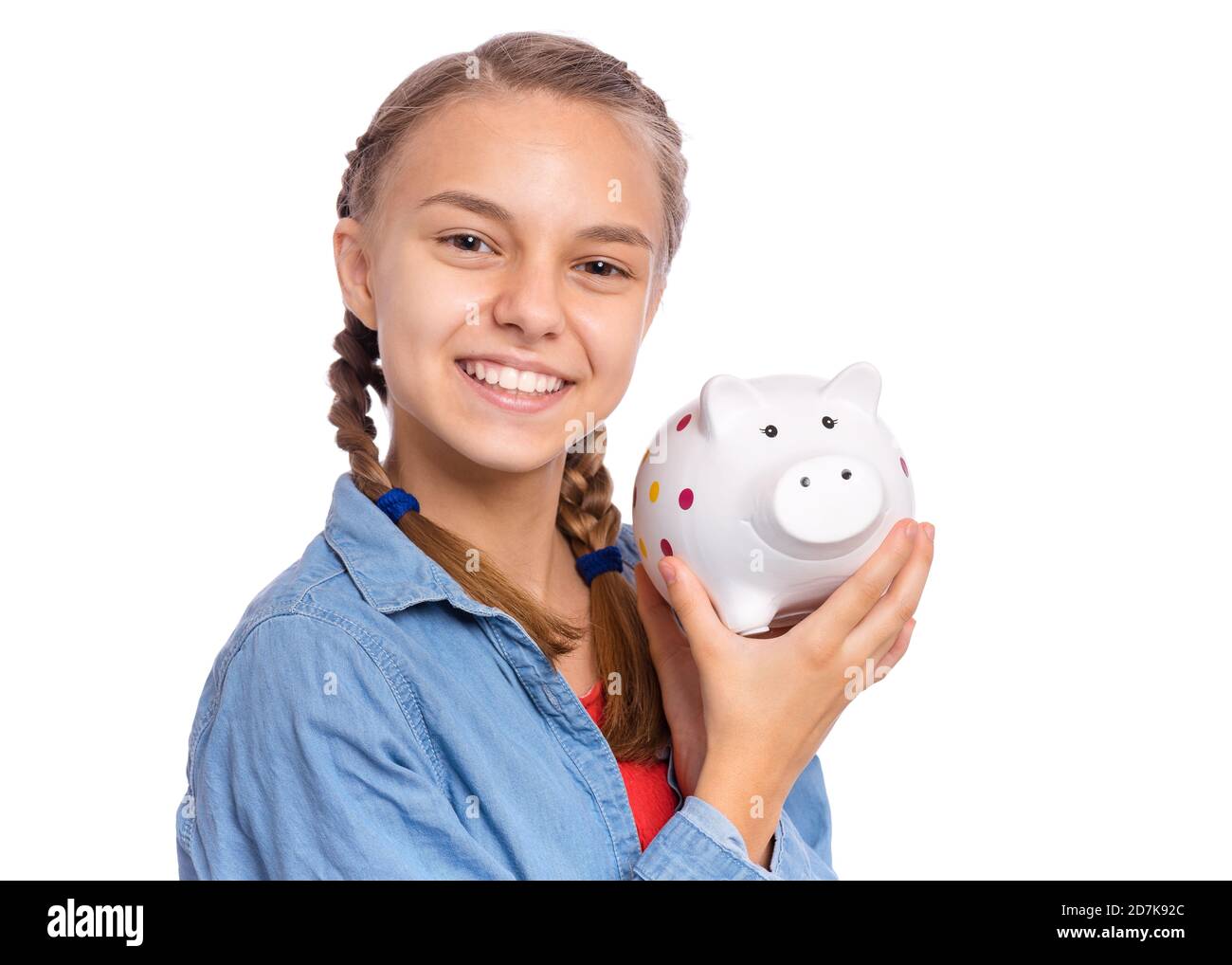 Beautiful teenage girl holds a piggy bank in her hands, isolated on ...