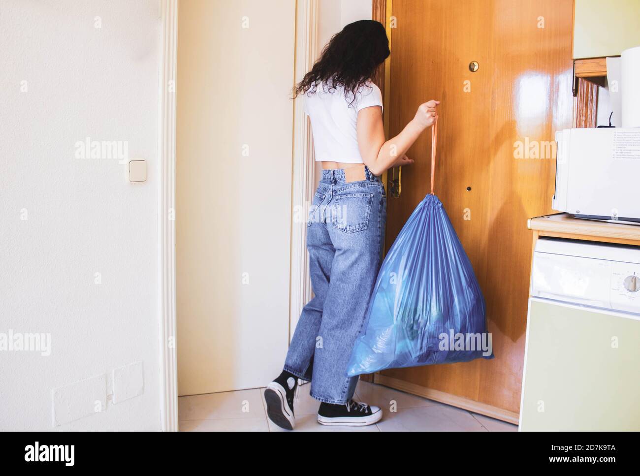 girl throwing garbage at the front door Stock Photo Alamy