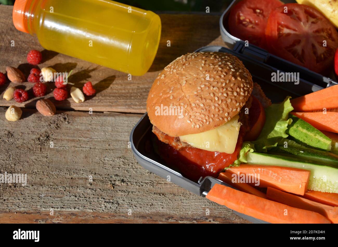 Lunch boxes with food ready to go for work or school, meal preparation or dieting concept. Hamburgers with lettuce. yellow orange juice. with banana Stock Photo