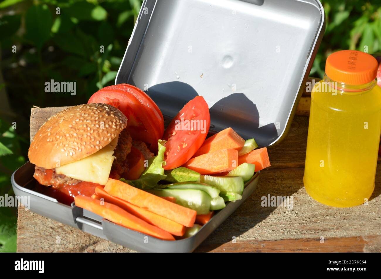 Lunch boxes with food ready to go for work or school, meal preparation or dieting concept. Hamburgers with lettuce. yellow orange juice. with banana Stock Photo