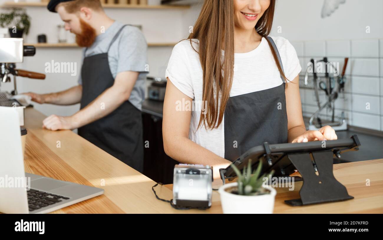 Coffee Business Concept - beautiful caucasian bartender barista or manager Posting order in digital tablet menu at modern coffee shop. Stock Photo