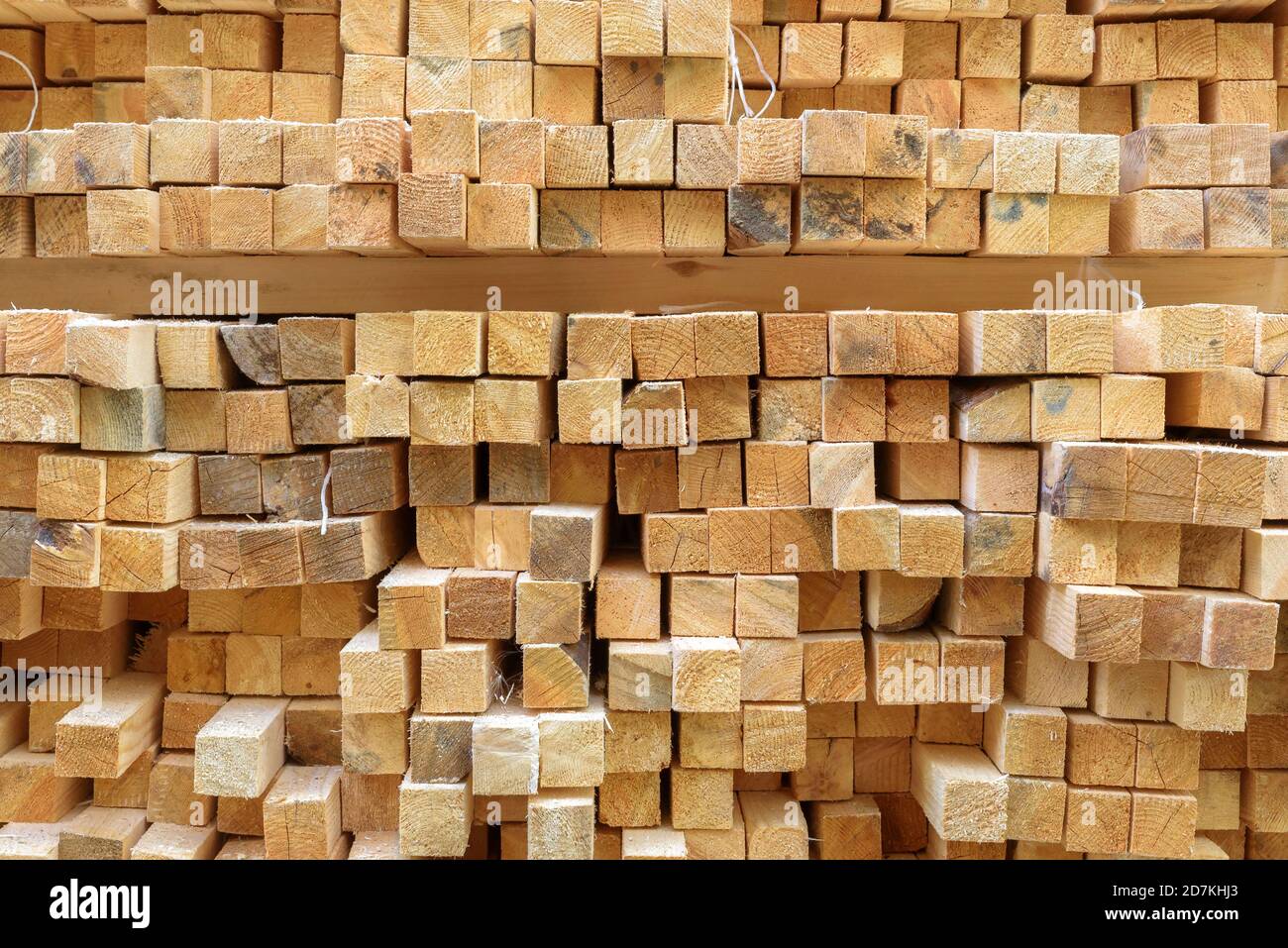 Lumber in sawmill, ends of timber blocks for texture background. Sawed and processed wood in storage, timber stack in factory yard. Pile of wooden boa Stock Photo