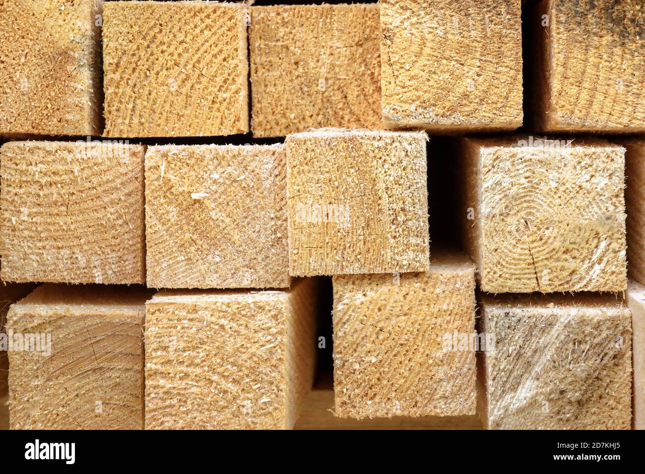 Lumber in sawmill, ends of timber blocks for texture background. Sawed and processed wood in storage, lumber stack in factory yard. Pile of wooden boa Stock Photo