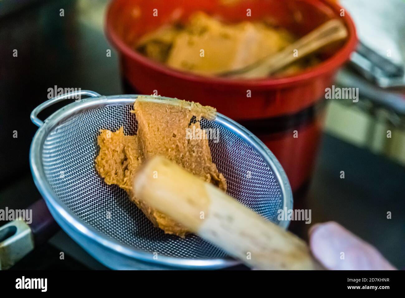 Making a Japanese miso soup in Nishiizu, Japan. Flavor booster and namesake of the soup. Only in the third step of the preparation the miso paste goes into the soup Stock Photo