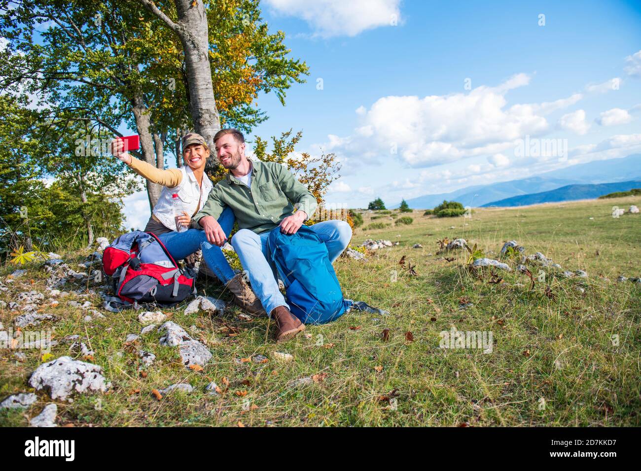 Cheerful young couple taking a selfie outdoor during the travel in the mountains Stock Photo