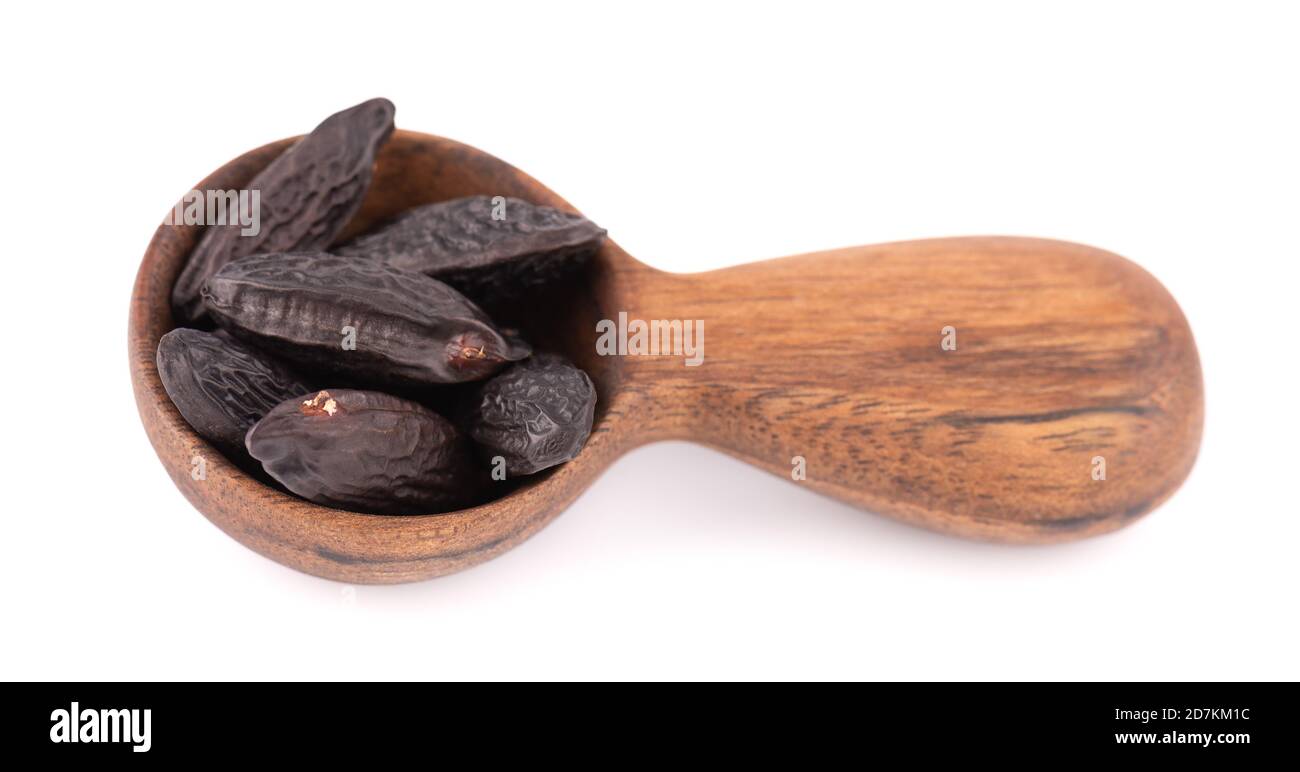 Tonka beans in wooden spoon, isolated on white background. Bean of