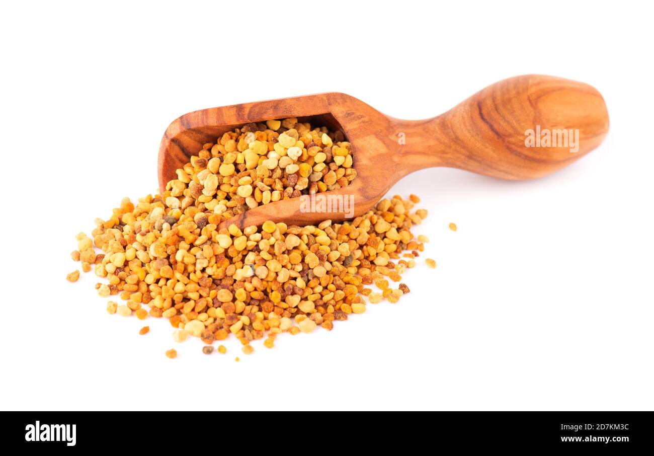 Flower pollen grains in wooden scoop, isolated on white background. Pile of bee pollen or perga. Stock Photo