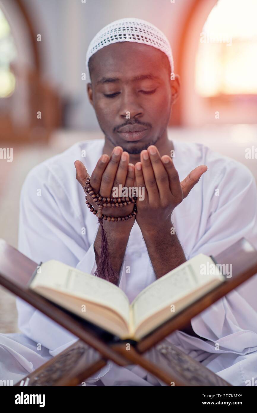 Religious black muslim man praying inside the mosque Stock Photo