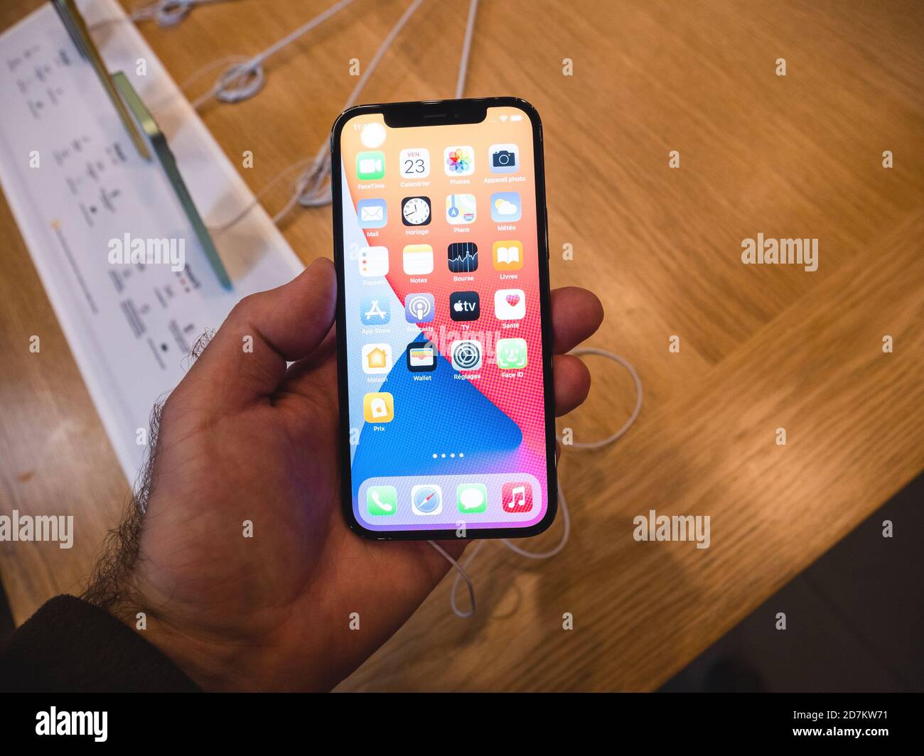 Paris, France - Oct 23, 2020: POV male hand looking at the new new iPhone 12 and iPhone 12 Pro during launch day in Apple Store. Latest 5G smartphones go on sale worldwide. Stock Photo