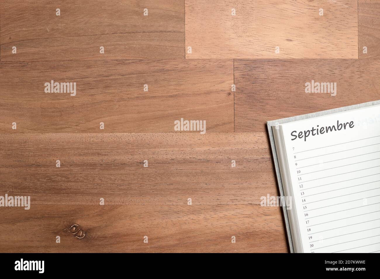 Blank page of a daily planner in Spanish for the month of September, on a wooden background. View from above with copy space Stock Photo