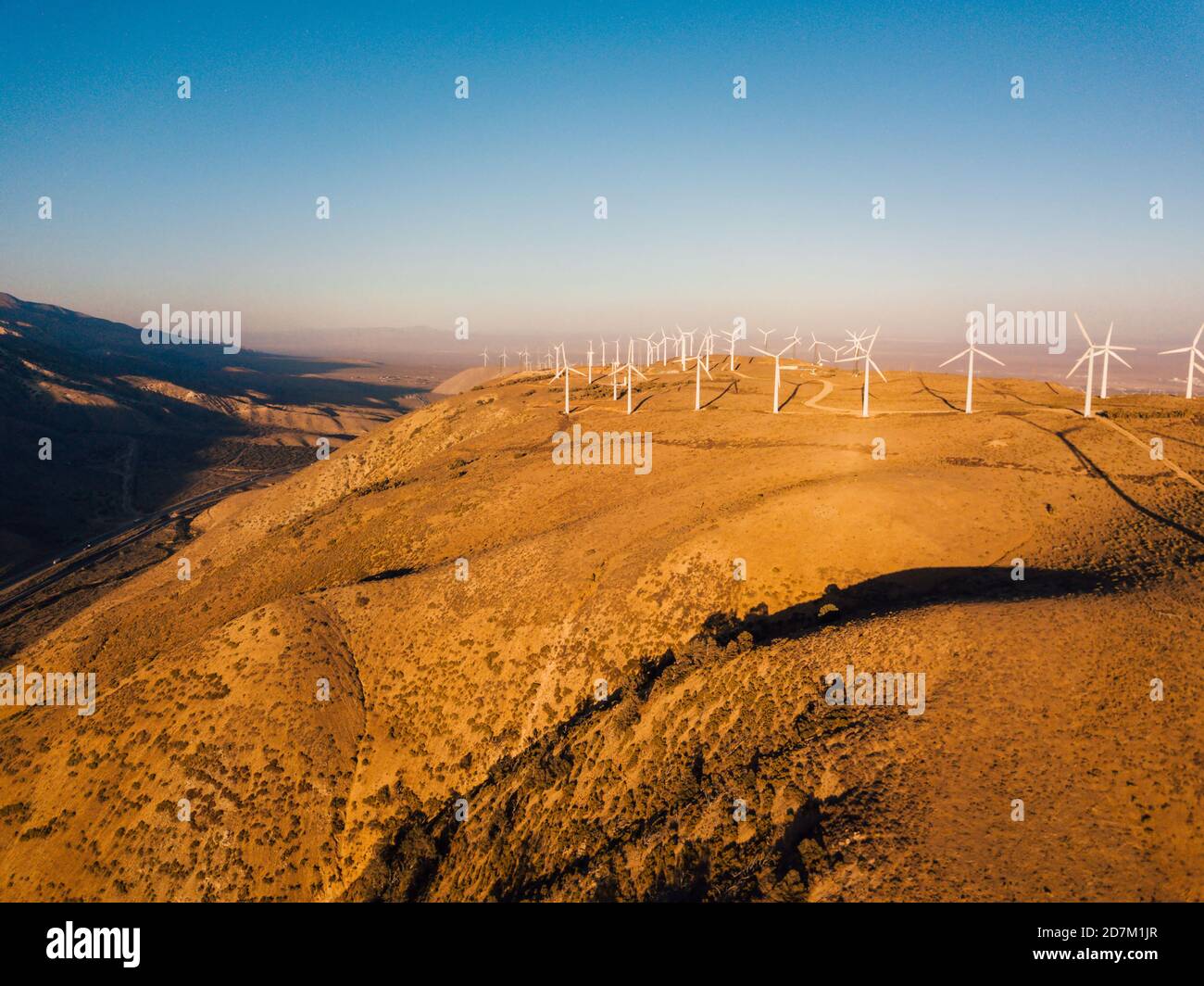 Wind turbines on top of a hill captured on a sunny day Stock Photo - Alamy