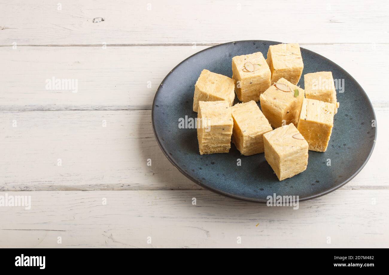 traditional indian candy soan papdi in a blue ceramic plate with almond