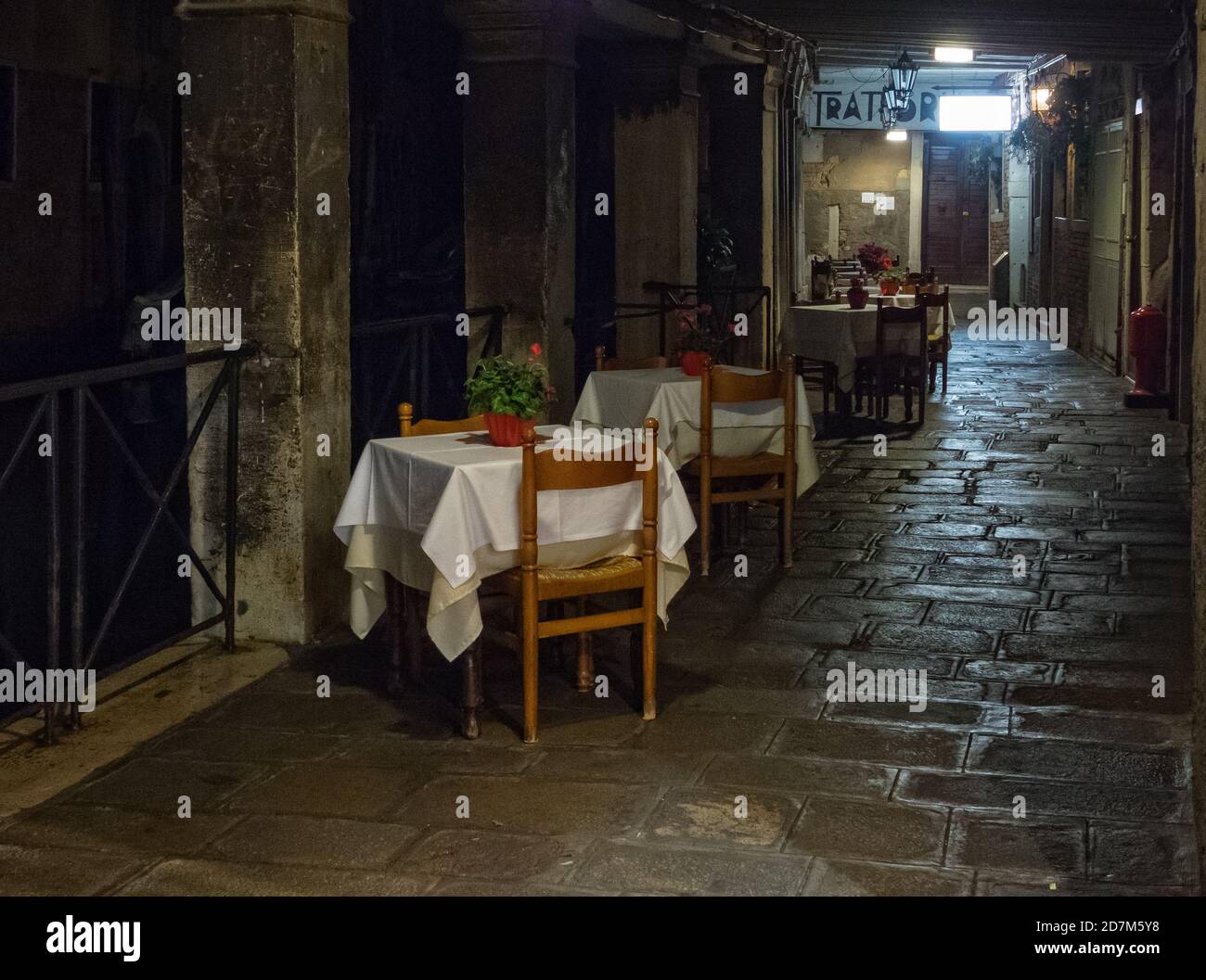 Tables waiting for dinner guests along the Rio dei Santi Apostoli - Venice, Veneto, Italy Stock Photo