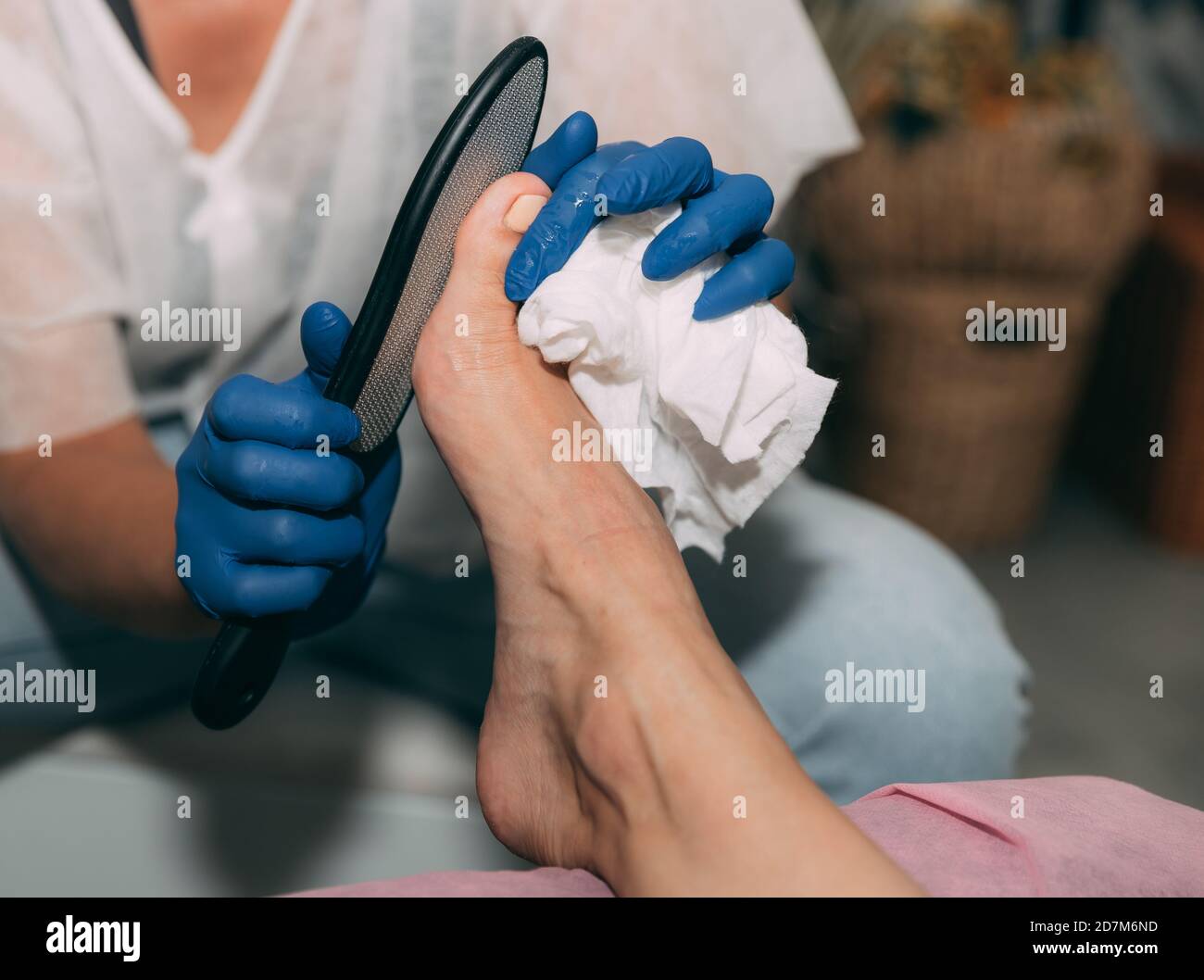 Peeling feet pedicure procedure in salon. Hardened leather grater. Leg of a young woman in Spa