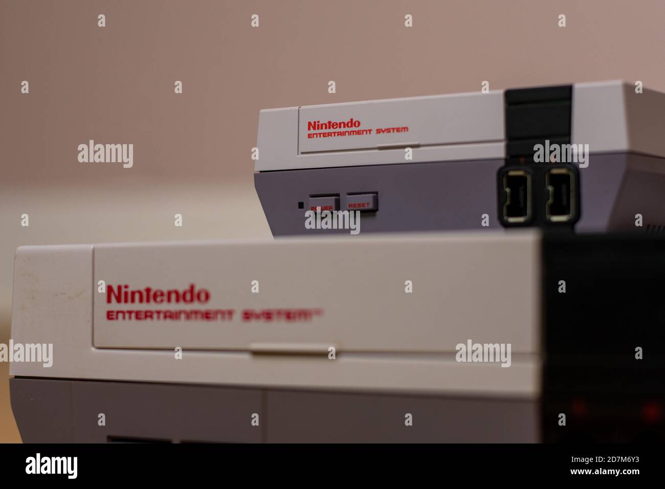 A Nintendo Entertainment System Classic Edition on Top of an Original Nintendo Entertainment System, on a wood floor. Comparison of the original NES a Stock Photo