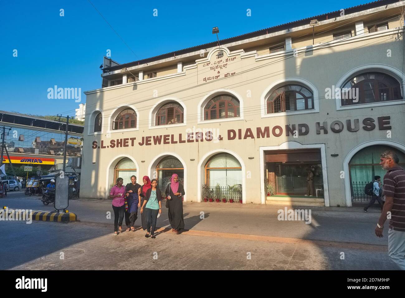 A group of young Indian women, Hindus and Muslims, walking in front of a prominent jewelry shop in the center of Mangalore, Karnataka, South India Stock Photo