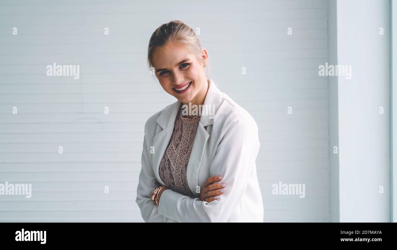 Attractive young woman profile portrait in office . Confident business person wearing formal suit working in corporate business. Stock Photo