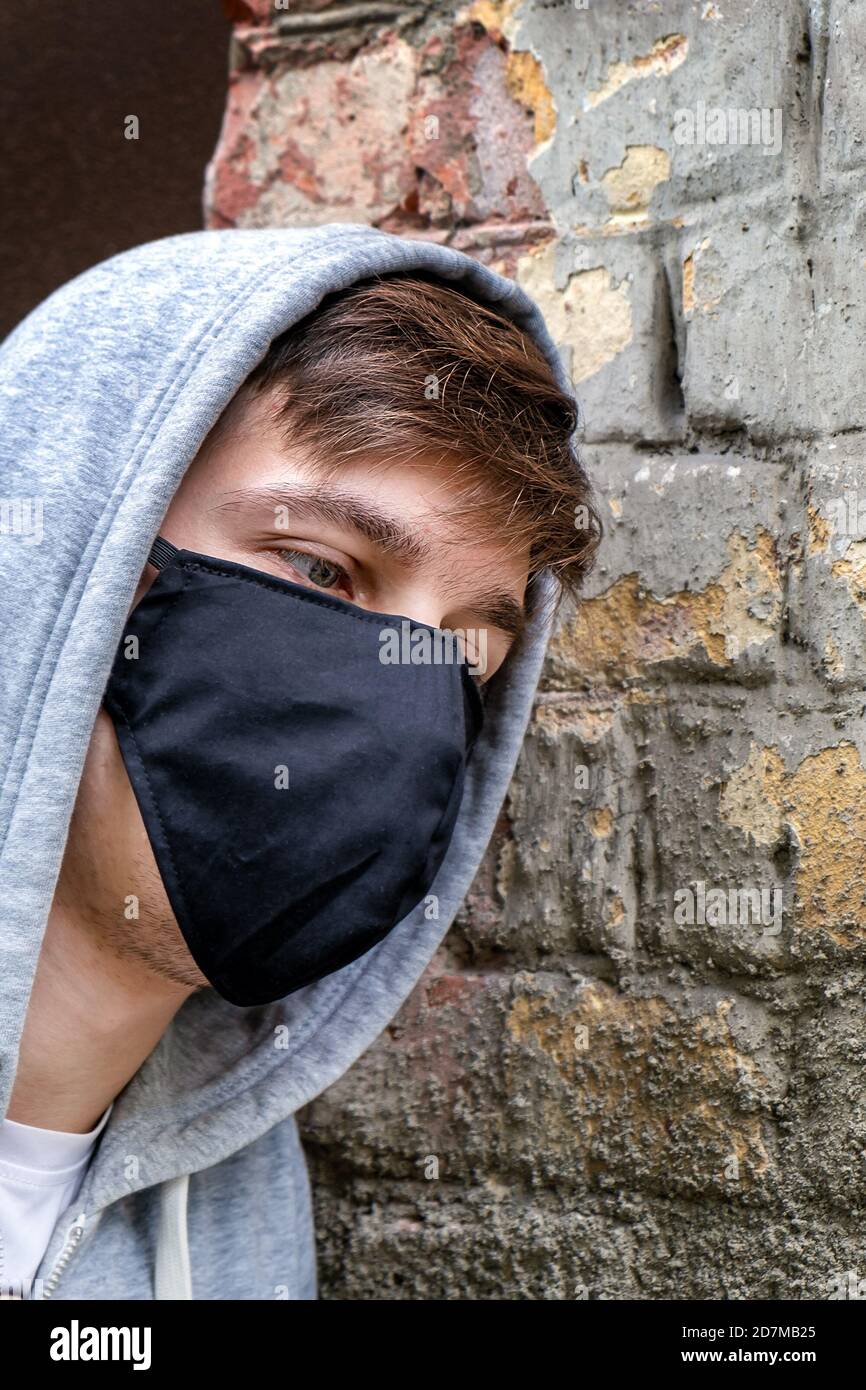 Young Man in the Flu Mask on the Old Wall Background outdoor Stock Photo