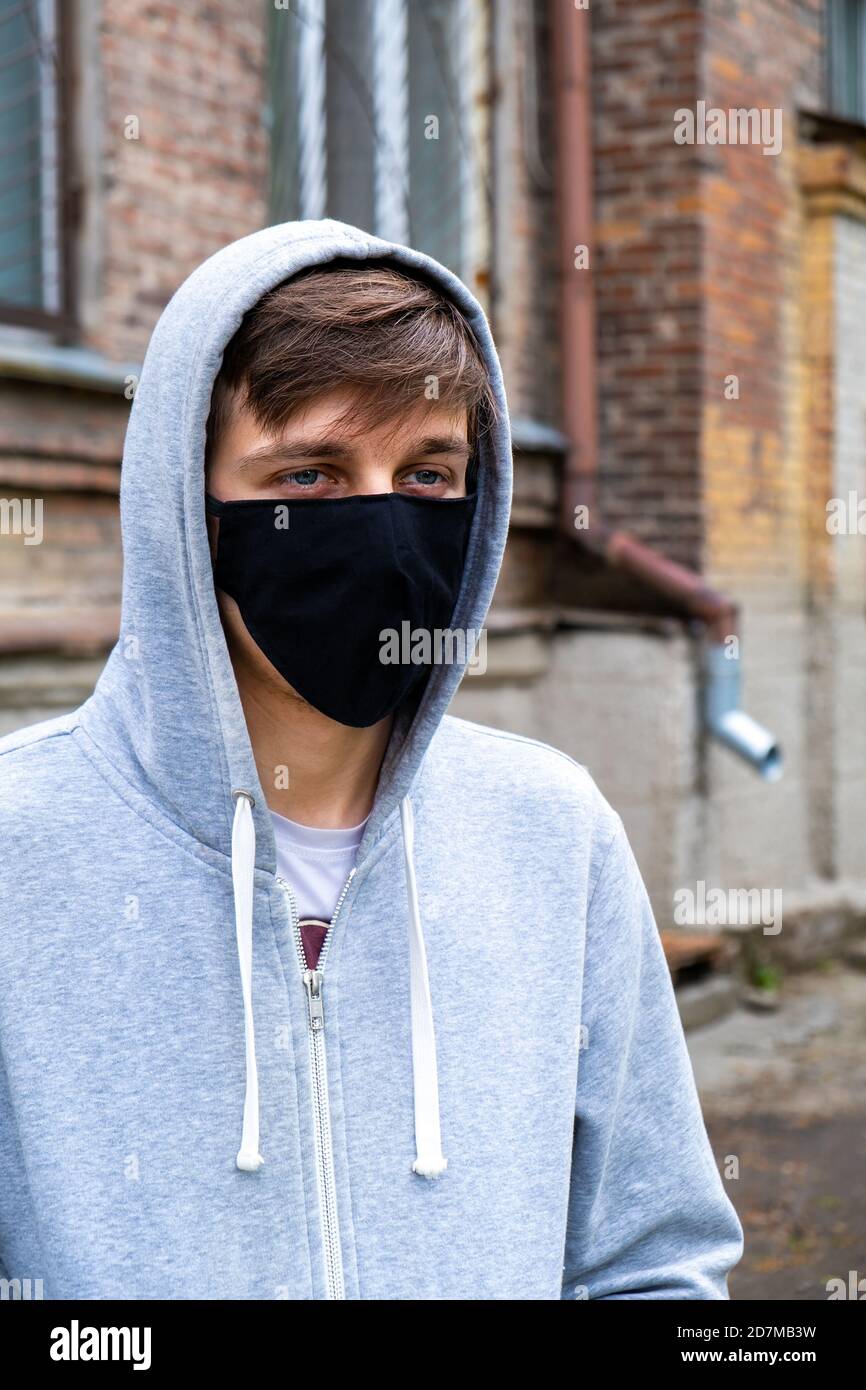 Young Man in the Flu Mask on the Old House Background Stock Photo