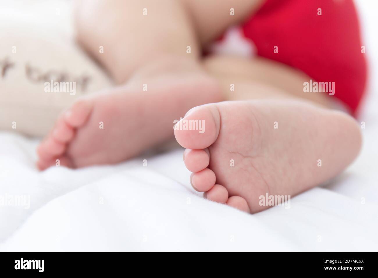The baby's feet are sleeping in the bed. Stock Photo