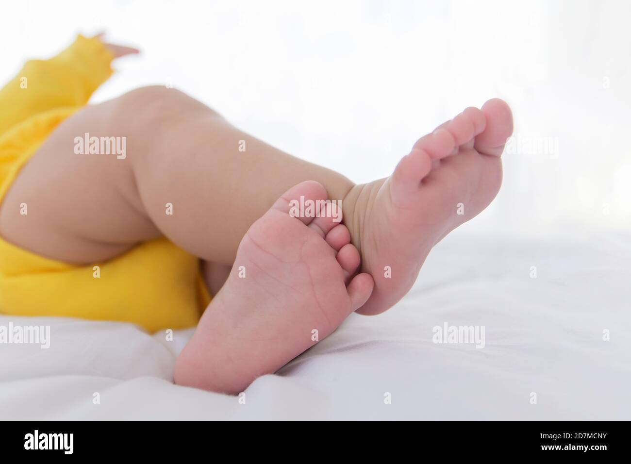 The baby's feet are sleeping in the bed. Stock Photo