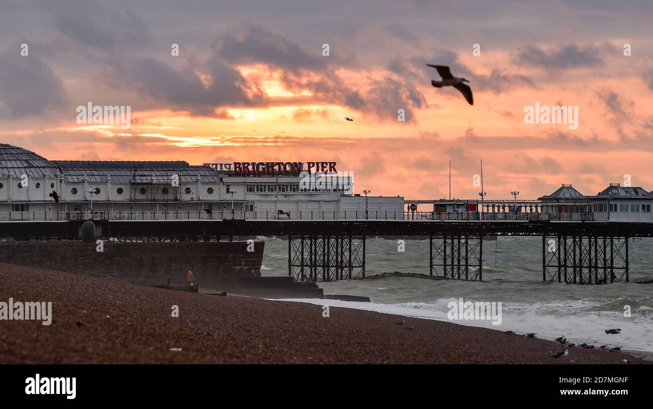 Brighton UK 24th October 2020 - The sun rises over Brighton Palace Pier on a blustery morning with the weather forecast to be more unsettled over the weekend throughout Britain : Credit Simon Dack / Alamy Live News Stock Photo