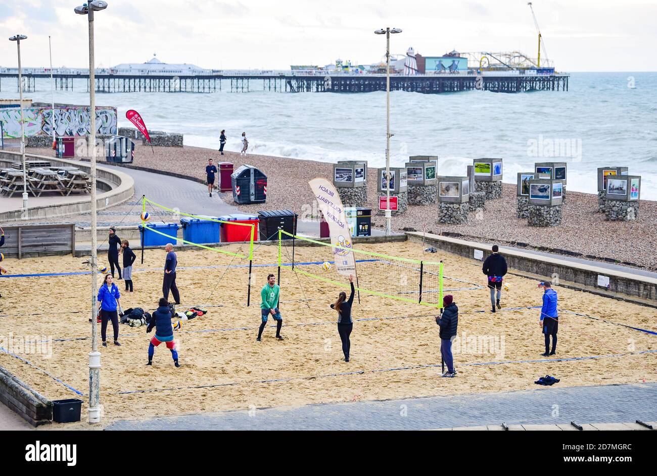 Brighton UK 24th October 2020 - Beach volleyball players out early on Brighton seafront on a blustery morning with the weather forecast to be more unsettled over the weekend throughout Britain : Credit Simon Dack / Alamy Live News Stock Photo