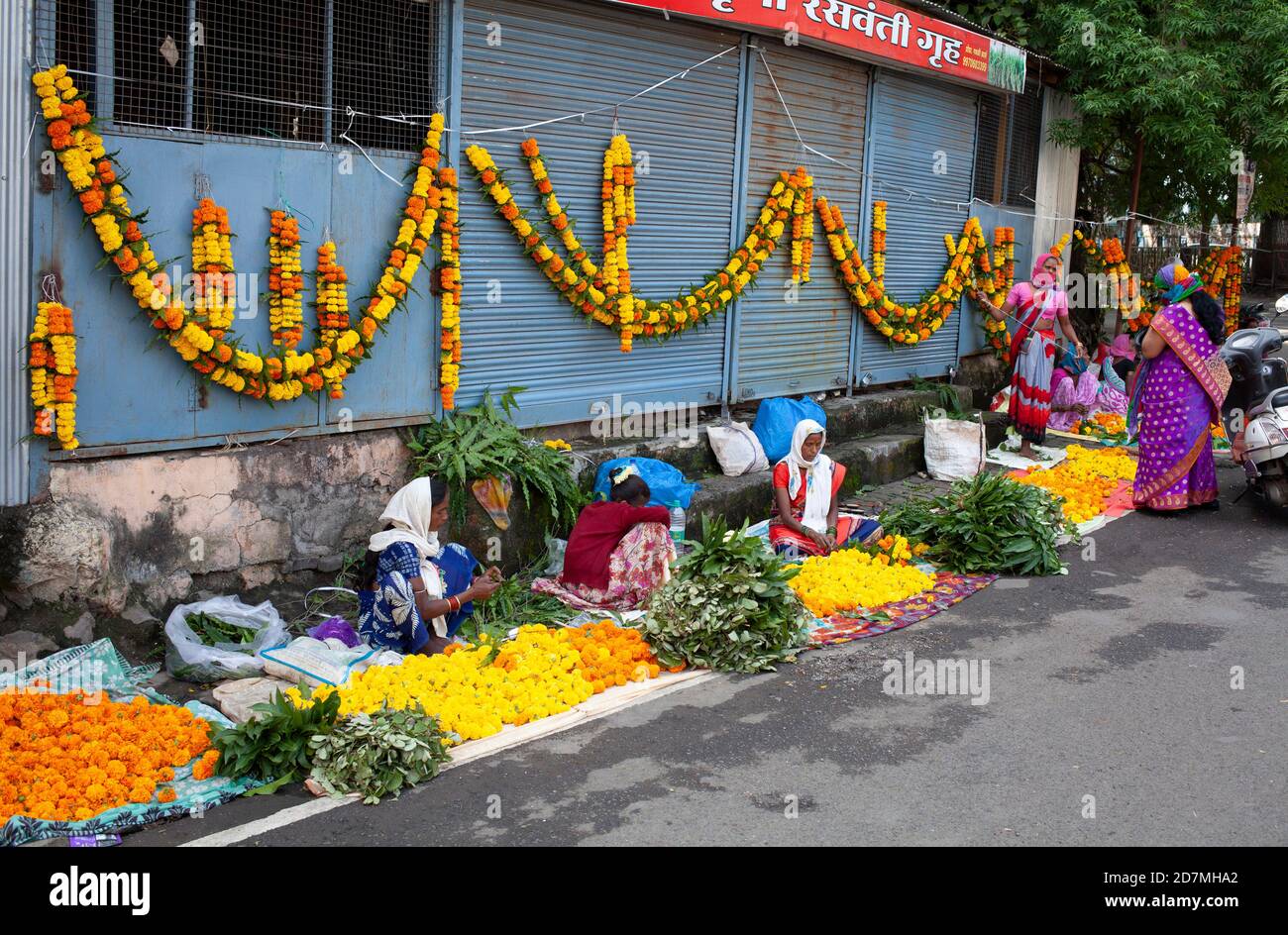 Women selling marigold flowers and garlands on the street on the eve of the festival of Dasara Location: Maharashtra, India Date: October 24 2020 Stock Photo