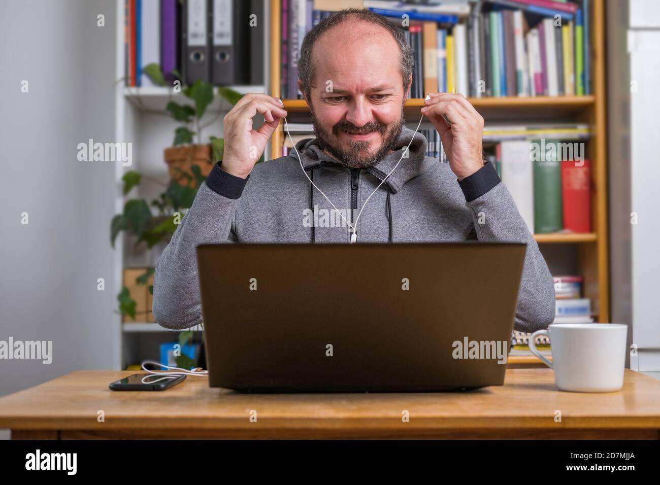 Man working online from home on computer laptop behind vintage desk ...