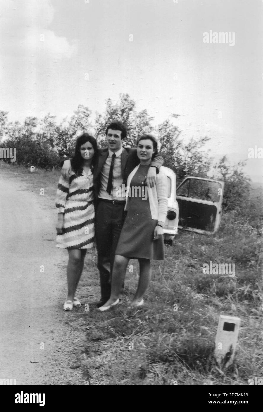 1970s Outdoor portrait of young friends in the countryside. Piandisco Arezzo, Tuscany Italy. Fiat 500. Black and white taken with 35mm film Stock Photo