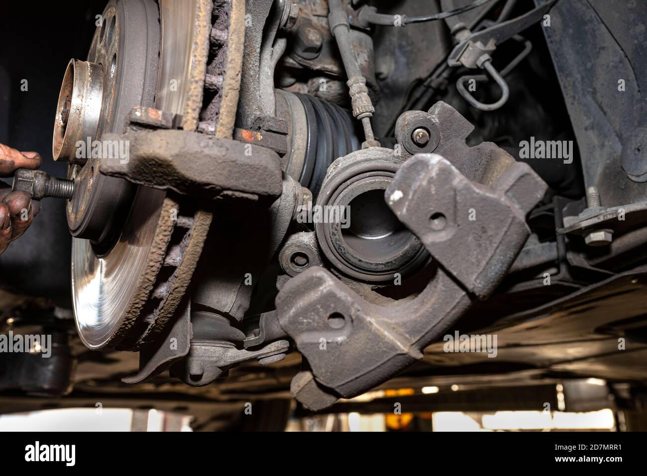 Disassembled front brake caliper on the car, which is on the car jack