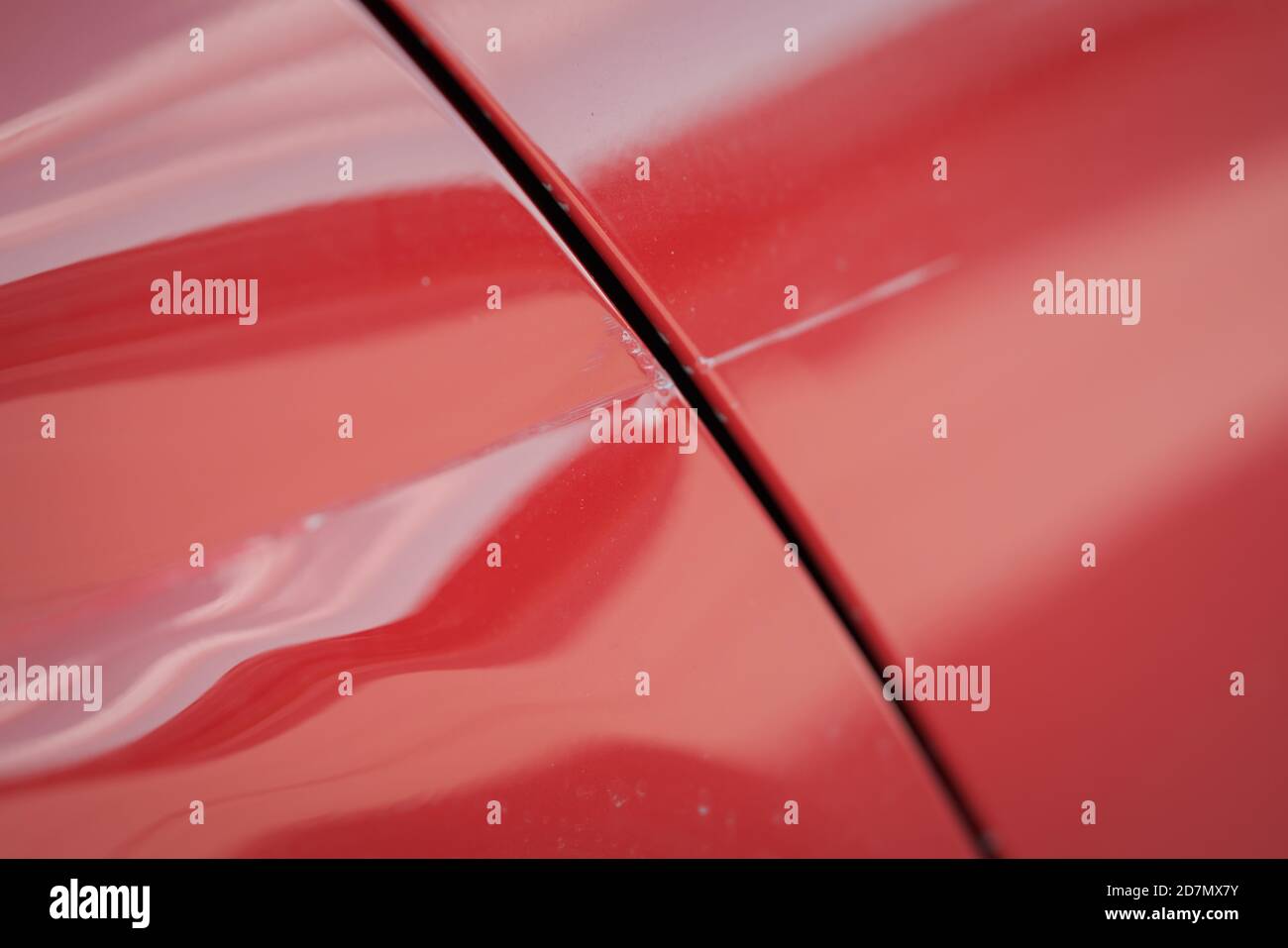 Closeup of red car with paint damage, long scratch, shallow focus Stock
