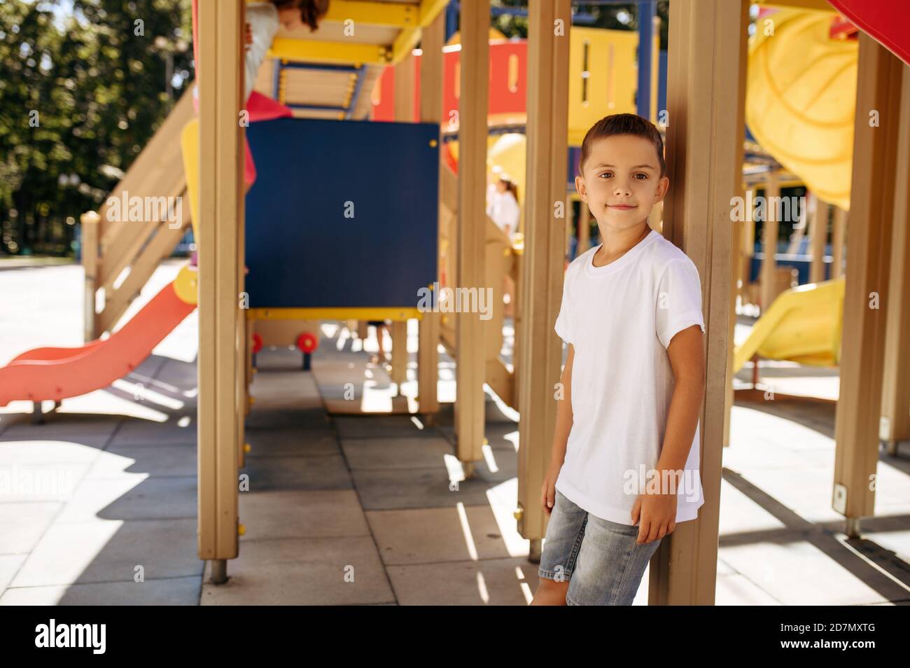 Little boy poses on playground, happy childhood Stock Photo
