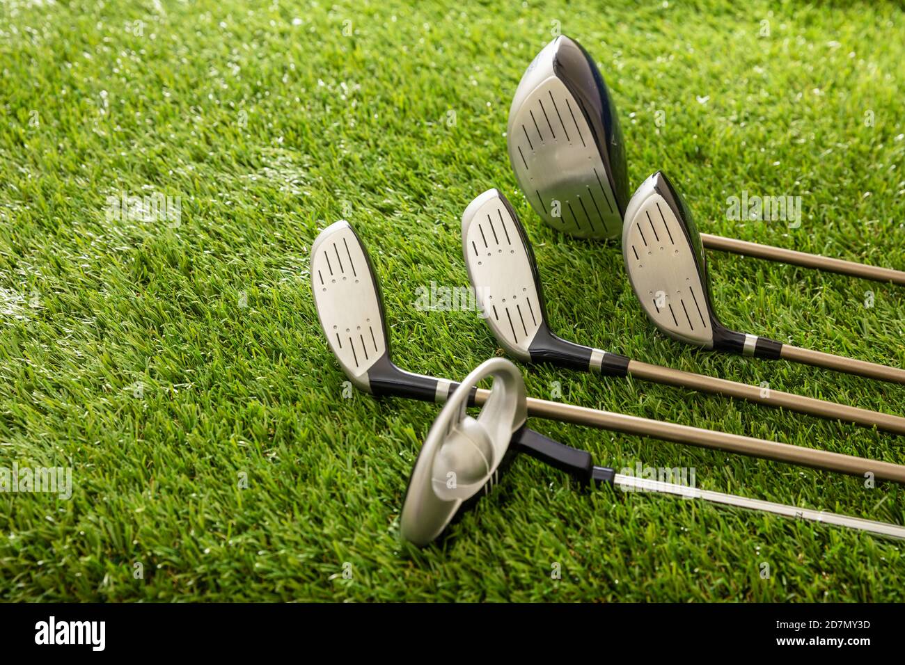 Golf sticks set on green course lawn, close up view. Golfing sport and club concept, copy space. Stock Photo