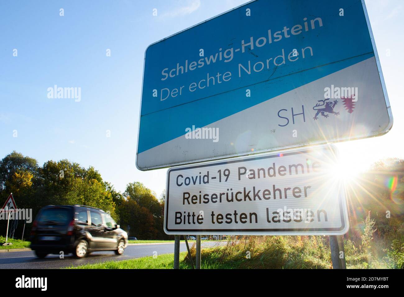 Flensburg, Germany. 24th Oct, 2020. A sign 'Covid-19 Pandemic - Travel returnees - Please get tested' on the B200 at the German-Danish border crossing informs travel returnees from Denmark about the general obligation to test. Credit: Gregor Fischer/dpa/Alamy Live News Stock Photo