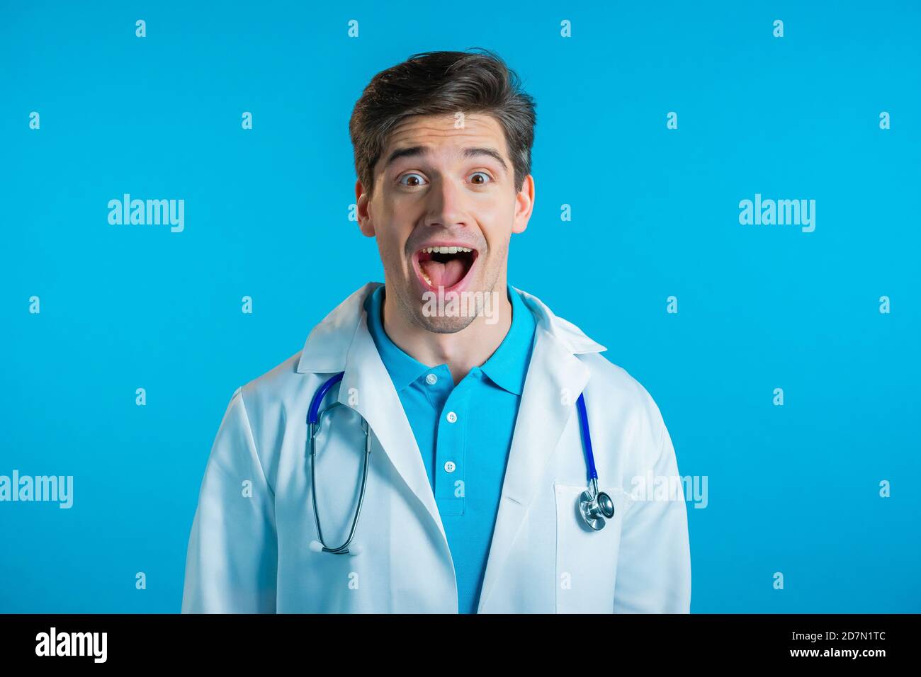 Amazed doctor man shocked, saying WOW. Handsome doc in medical coat