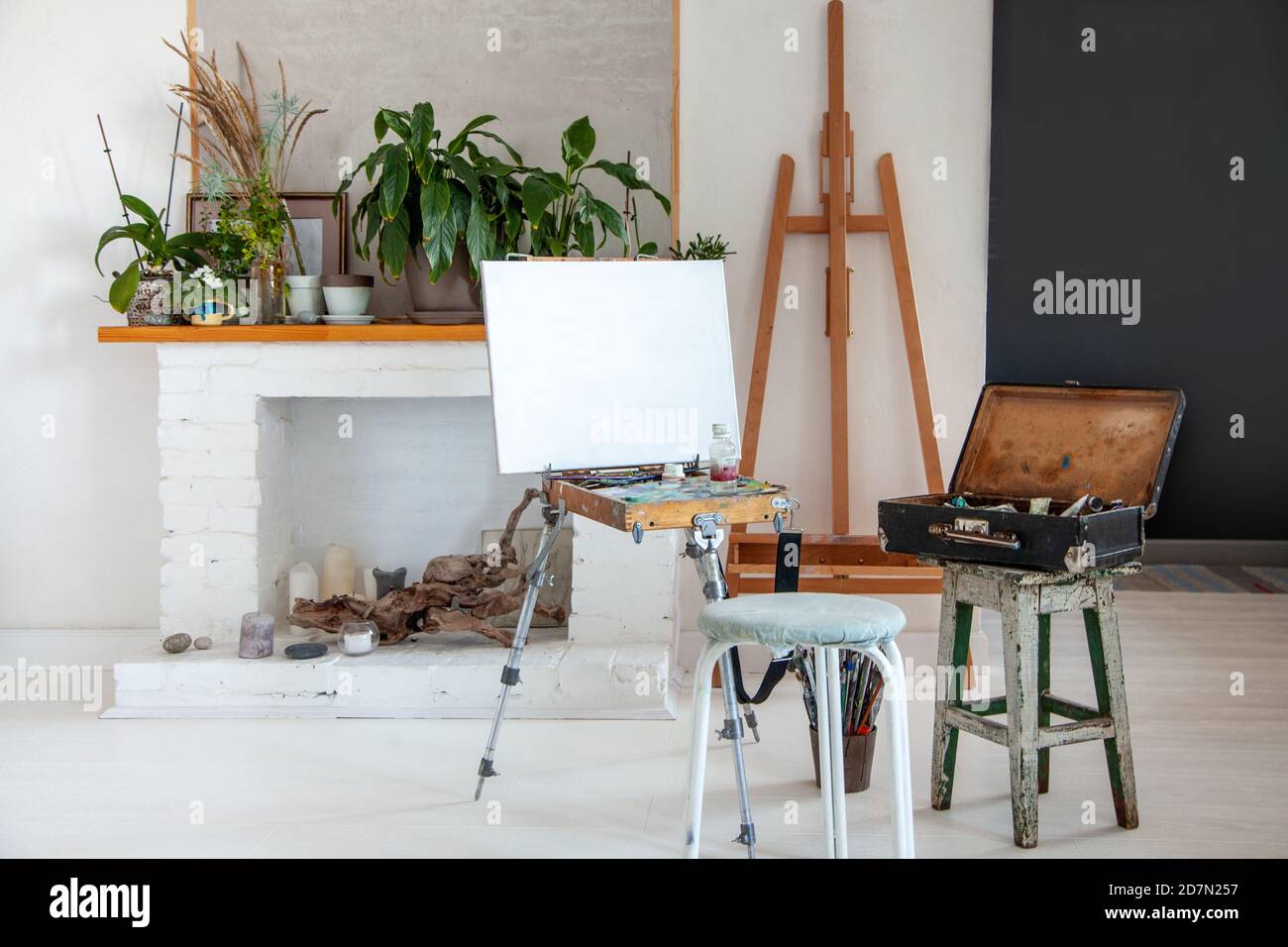 Art studio interior with painting supplies, canvas on easel, paintbrushes, vintage oil paint box Stock Photo