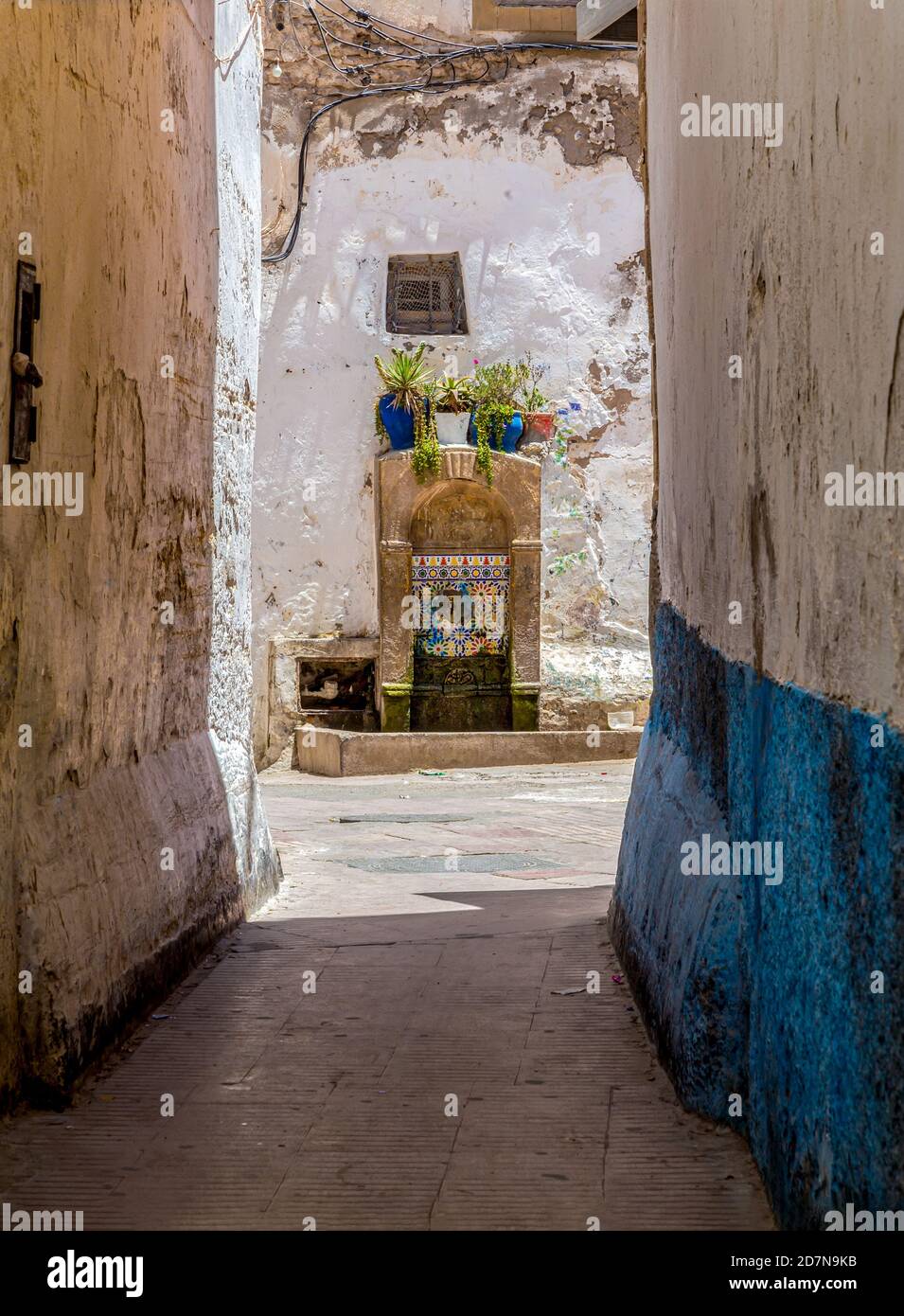 Typical narrow street with Moroccan mosaic decoration drinking fountain in the Medina of Essaouria,Morocco. Stock Photo