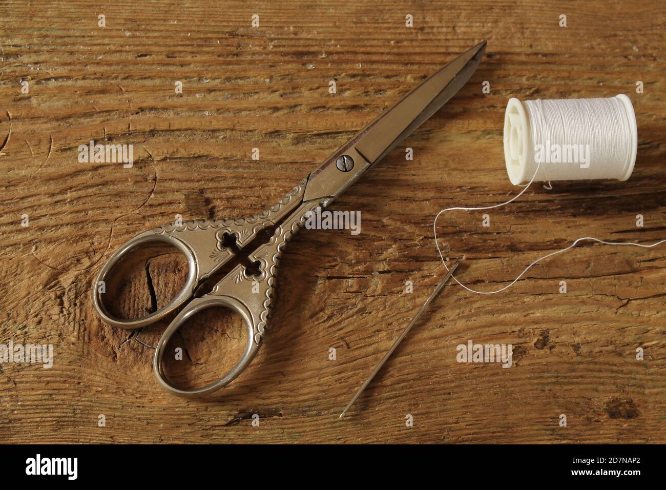 Old scissors with needle and thread Stock Photo