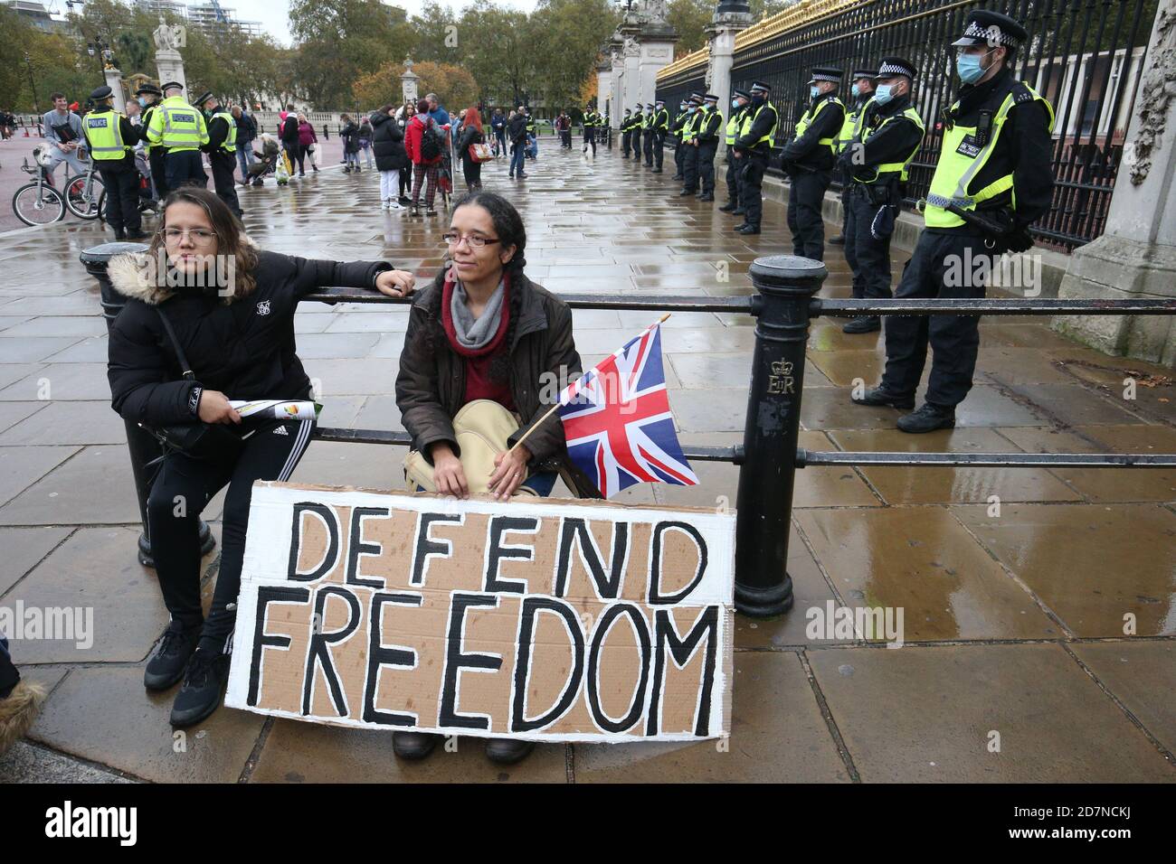 Demonstrators sit in front of a police cordon outside the main gate of Buckingham Palace, London, during a protest against the lockdown restrictions brought in to prevent the spread of coronavirus. Stock Photo