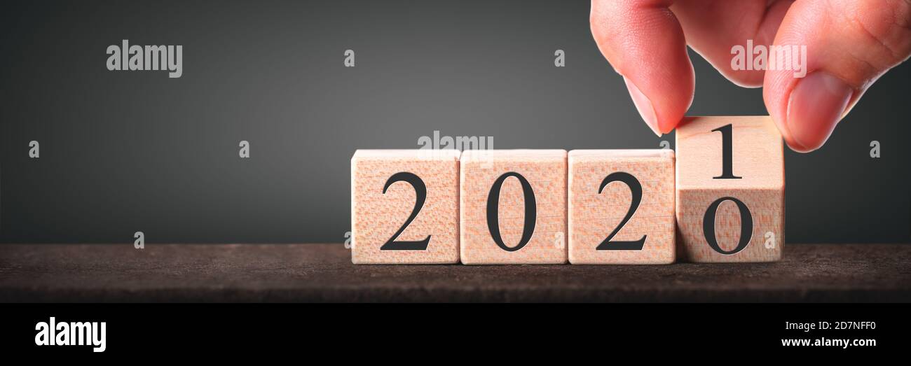 Hand Changing Date From 2020 To 2021 On Wooden Cube Calendar - New Year's Concept Stock Photo