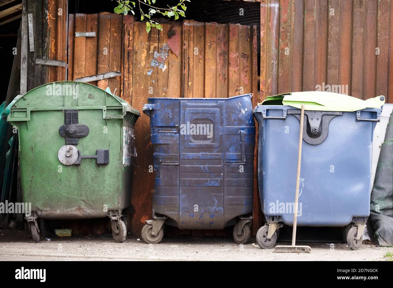 Blue recycle wheelie bins in row for collection outside house Stock